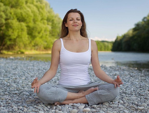 Lady meditating in nature with eyes closed. Feeling calm and positive. 